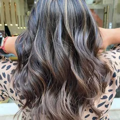 A perfect example of a sun-kissed caramel balayage on a dark base. I hand-painted these highlights to create a seamless, natural-looking blend that adds warmth and dimension. The final style with soft waves really makes the caramel tones pop.