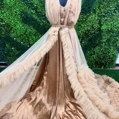This gorgeous beige ruffle gown is displayed on a mannequin, showing off its flowing layers and elegant design.