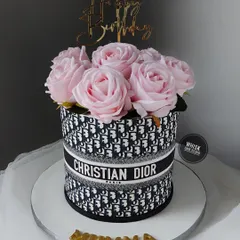An elegant Dior-themed cake. This design replicates the iconic Dior pattern and is topped with a bouquet of beautiful pink sugar roses.