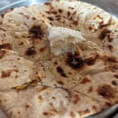 A rustic and flavorful Besan ki Tandoori Roti, topped with a dollop of white butter. This special roti has a unique, nutty flavor from the gram flour.