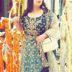 A closer look at the intricate gold floral embroidery on the bodice of the dark green Anarkali. The matching dupatta completes this classic ethnic wear look.