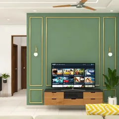 We used classic wall moulding with a sage green paint and gold trim to create an elegant feature wall for the TV. The floating wooden console with black accents provides a modern contrast.