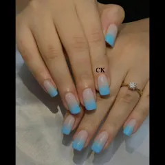 A beautiful blue ombre on square-shaped nails, fading from a nude base to a bright sky blue.