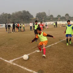 A player controls the ball near the sideline during a fast-paced league match.