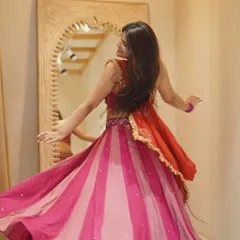 A beautiful pink and orange striped lehenga in full twirl. This outfit is perfect for a daytime Mehendi or a vibrant sangeet night.