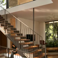 A quiet moment of afternoon light at the Debris Block House. The open, multi-level staircase is not just for circulation; it's a place to pause and a channel for sunlight to filter through the home.