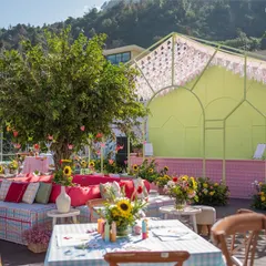 A cheerful and colorful seating area at our 'Picnic in the Mountains' mehendi, complete with a tree centerpiece and gingham-patterned furniture.