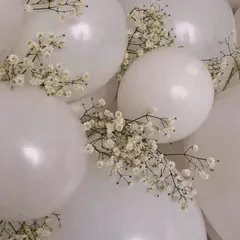 We love adding delicate, natural touches to our decor. This close-up shows how we weave sprigs of baby's breath into an arrangement of pure white balloons, adding a touch of softness and elegance.
