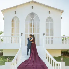 This special setup with a pristine white facade offers a touch of European elegance right here in Jaipur. The bride's deep purple gown with its long train creates a stunning visual on the grand staircase.