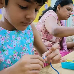 As part of our Friendship Day celebrations, this student is carefully threading beads to create a special bracelet. This activity not only results in a lovely keepsake but also enhances focus and hand-eye coordination.