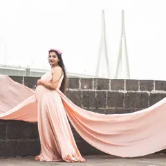 This elegant peach maternity gown features a double trail for added flair. It’s an excellent choice for capturing stunning portraits with an urban backdrop, like the Mumbai sea link seen here.