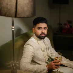 A stylish, moody portrait of the groom, capturing a moment of calm and contemplation.
