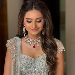 The gentle smile of a happy bride. Her hair is styled in simple yet stunning soft waves, a versatile choice that pairs beautifully with any modern bridal outfit.