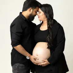 An intimate and modern studio portrait of an expecting couple, focusing on their connection and the beautiful baby bump. This simple, clean style creates timeless and emotional pregnancy photos.