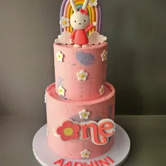 Say hello to Miffy! This two-tier cake for Aadhini's first birthday features the adorable bunny Miffy, along with a pastel rainbow and cute floral details.