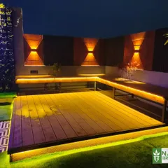 Custom L-shaped seating and deck area in the Uttam Nagar project, brought to life at night with warm, indirect LED strip lighting.