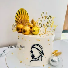 Simplicity, elegance, and a sprinkle of gold. This minimalist cake features a modern line-art face, gold leaf, and disco ball accents.