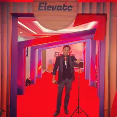 Ready to entertain at the 'Elevate' event. With my iPad and stand, I can set up anywhere and start performing, making me a flexible entertainment option for any event layout.