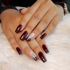 A beautiful set of square-shaped extensions in a deep, glossy red, with a modern accent nail featuring a silver glitter reverse French tip.