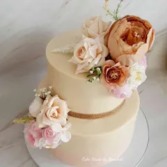 I was given creative freedom for this stunning wedding cake, finished in soft pink and nude shades. I used only white chocolate ganache to create this smooth, elegant look, adorned with beautiful silk flowers.