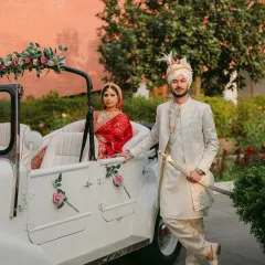 A portrait of regal elegance. Ambika and Sidhant pose with a vintage car, creating a grand and timeless image that celebrates their beautiful union and cultural heritage.