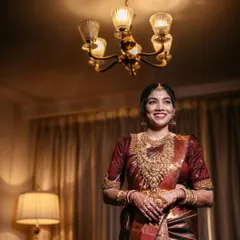 A radiant bridal portrait, her happy smile captured under the warm glow of a chandelier.