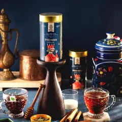 A royal and spicy setup for Hindraj's Spiced Nawab Masala Tea. The use of traditional brassware, deep colors, and whole spices creates a rich, aromatic visual story that speaks to the tea's heritage.