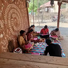 Our students learning the art of Warli painting while sitting in the shade of a traditional mud home. The environment itself becomes a source of inspiration.