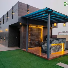 The completed outdoor bar and kitchen area at our Sushant Lok site, with a marble-clad counter and a pergola roof.