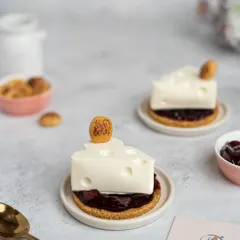 We love to have fun with our desserts. Our Wild Cherry Cheesecake is a playful twist on a classic, crafted to look like a wedge of cheese, complete with a buttery crumble base and a rich wild cherry compote filling.