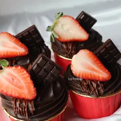 Decadent chocolate cupcakes topped with a fresh strawberry slice and a piece of dark chocolate. A perfect combination.