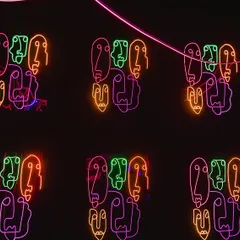 We used custom neon signs with abstract face motifs to decorate the walls. The multi-colored lights created a vibrant, artistic, and energetic atmosphere, perfect for a modern party.