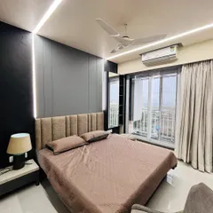 I create bedrooms that are true retreats. This project features modern dark paneling, ambient strip lighting along the ceiling and headboard, and an upholstered bed to create a cozy, sophisticated atmosphere.