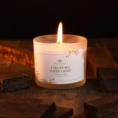 A moody, atmospheric shot of a lit 'Mahogany Musk' candle, styled with dark wood to evoke a sense of warmth and trust. We excel at creating specific moods, from bright and airy to cozy and intimate, for home decor and lifestyle brands.