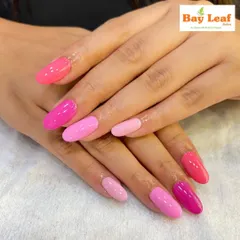 We have a pink for every mood. This photo showcases a beautiful gradient of pink shades, from a deep magenta to a soft baby pink, on perfectly shaped oval nails.