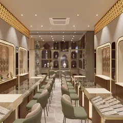 A perspective shot of the redesigned jewellery showroom, showing the flow between different counter sections. The combination of warm wood tones, green velvet chairs, and intricate gold-toned ceiling details creates a cohesive and luxurious atmosphere.