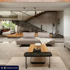 This shot from the Elle Decor feature captures the grand, open-plan living and dining area of Villa Shakthi. The dramatic staircase and double-height volume are central to the home's design, creating a sense of spaciousness and connection.