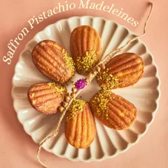 Our Saffron Pistachio Madeleines, arranged in a flower shape around a rakhi.