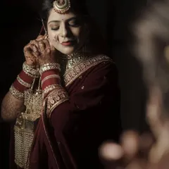 A quiet moment during the getting-ready process. The soft lighting and the bride's focused expression as she puts on her earrings create an intimate and beautiful portrait.