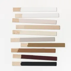 The details make the design. This image shows a selection of wood samples with different paint and stain finishes, representing the careful process of choosing the perfect colors and materials to create a cohesive and beautiful space.