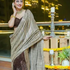 A guest enjoying a Diwali party we styled. The decor features rustic wooden crates, marigold flowers, and candles, blending traditional elements with a modern aesthetic.