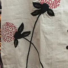 A close-up of the beautiful floral embroidery on a cotton-linen co-ord set. This breathable fabric is perfect for summer, and the embroidery adds a touch of artisanal charm.