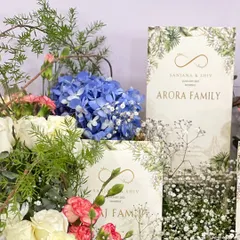 A closer look at the floral details in my blossom-themed invitation hamper. I use a mix of fresh hydrangeas, roses, and baby's breath to frame the custom-printed invitation cards, creating a lush, garden-like feel.