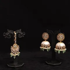 This rental set includes beautiful jhumkas with mint green enamel work and a matching maang tikka, perfect for a coordinated look.