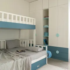 For this children's room, I designed a custom bunk bed and wardrobe combination to maximize space and fun. The calming blue and white palette, along with arched details and integrated shelving, creates a functional sanctuary for play, study, and rest.