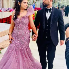 We love helping couples coordinate their looks. She is dazzling in a pre-owned lavender fish-cut gown with intricate floral embroidery, while he looks sharp in a classic black tuxedo. Find your perfect pair of outfits with us.