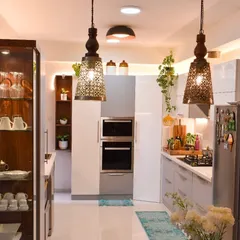 A view from the dining area into the kitchen. The pendant lights add a touch of traditional charm to the otherwise modern space.