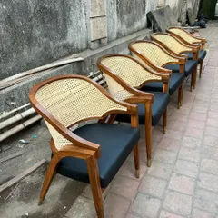 A set of my mid-century dining armchairs with black leatherette seats and caned backs, lined up for delivery to a restaurant client. The brass-capped legs add a touch of elegance.