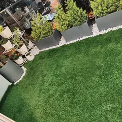 I transformed this city rooftop into a chic green oasis. The artificial grass installation provides a beautiful, soft surface underfoot, complemented by modern planters and lighting, making it the perfect spot for evening relaxation with a view.