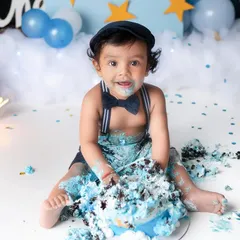 This little gentleman, complete with a dapper bowtie, is having the time of his life at his first birthday cake smash. The pure joy of this moment is just priceless.